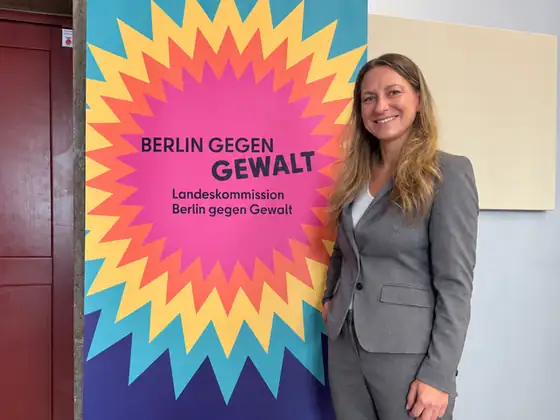 Sarah Perry vor einem Roll-up der Landeskommission Berlin gegen Gewalt